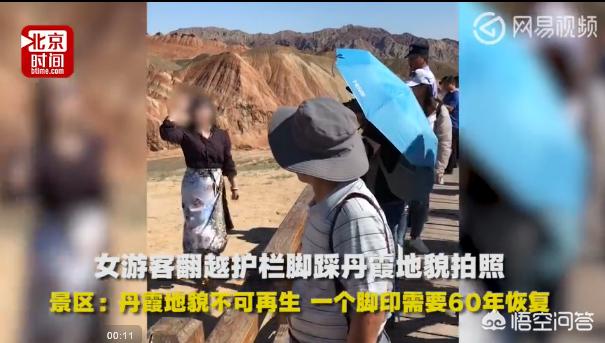 男子丹霞景区翻护栏，游客翻越护栏脚踩丹霞地貌拍照