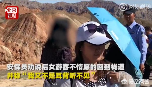 男子丹霞景区翻护栏，游客翻越护栏脚踩丹霞地貌拍照