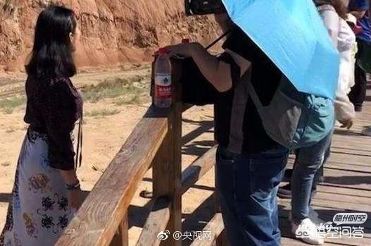 男子丹霞景区翻护栏，游客翻越护栏脚踩丹霞地貌拍照