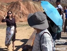 男子丹霞景区翻护栏，游客翻越护栏脚踩丹霞地貌拍照